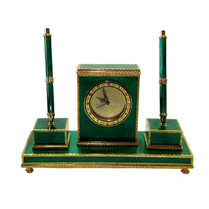 6607-7645 - Desk centerpiece in 925/1000 sterling silver gold plated with translucent fire enamels on guilloche and hand engraved finish, late French Empire Napoleon III style. Made up of a central parallelepiped clock cm. 9 x 12,5 x 3 mounted on a rectangular base cm. 9,5 x 25,5 with feet and flanked by two pens, one fountain pen and the other ballpoint, on an articulated support, total height cm. 20. Weight gr. 1.930- Swiss mechanical movement with 8 days charge and alarm. Designed by Giorgio Salimbeni and made in Florence in 2012 in the Salimbeni's factory with manual workmanship of talented artisans with high thickness plate and big reinforcements suitable to support many firings of enamelling at high fire at about 800° C.
