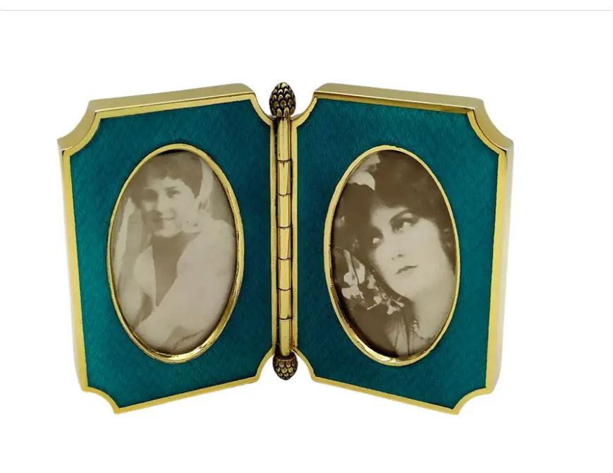 1735-6317 - Shaped double opening photo frame in 925/1000 sterling silver gold plated with translucent fired enamel on guillochè. Early 1900s English Art Nouveau style. Open size cm. 13.5 cm high. 9.2. weight gr. 163. Designed by Giorgio Salimbeni in 1980 and produced in various specimens, even in different colours, in the Salimbeni company headquarters with manual workmanship by skilled artisan artists with a thick slab suitable for withstanding numerous enamelled firings over a high heat at about 750°