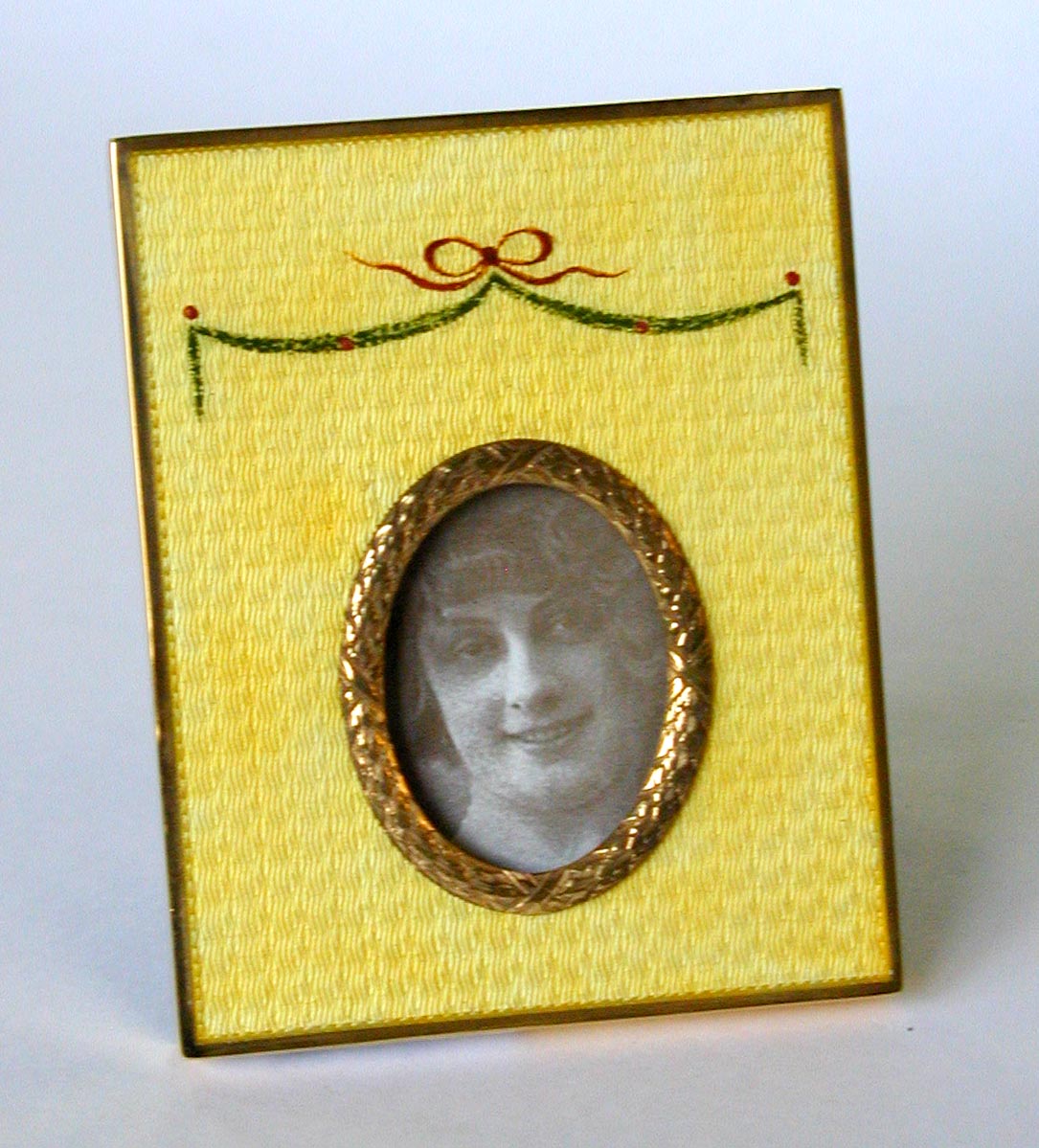 Rectangular photo frame in sterling silver 925/1000 gold plated with translucent fired enamels on guillochè with hand-painted floral miniature, and oval ornament around the opening, Russian Empire Fabergè style. Blue velvet panel. External measure cm. 8 x 10. Oval interior cm. 3.1 x 4.2. Weight gr. 123. Produced in Florence at the Salimbeni company headquarters in 1969