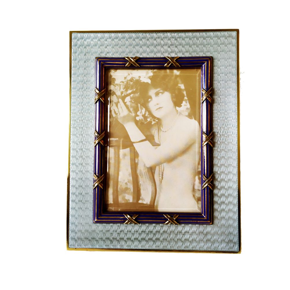 1411-5630 - Photo Frame rectangular in 925/1000 sterling silver gold plated with translucent fired enamel on guillochè and with convex border with enamelled lines, on which are applied interlacements in French Empire Louis XVI style. External cm. 14 x18 internal measurement cm. 7.8 x 11.8. Weight gr. 378. Designed by Giorgio Salimbeni in 1982 on inspiration from previous frames also manufactured in the Salimbeni company headquarters with manual workmanship by skilled artisan artists with a thick plate suitable for supporting numerous high-fire enamelled firings at around 800° C.