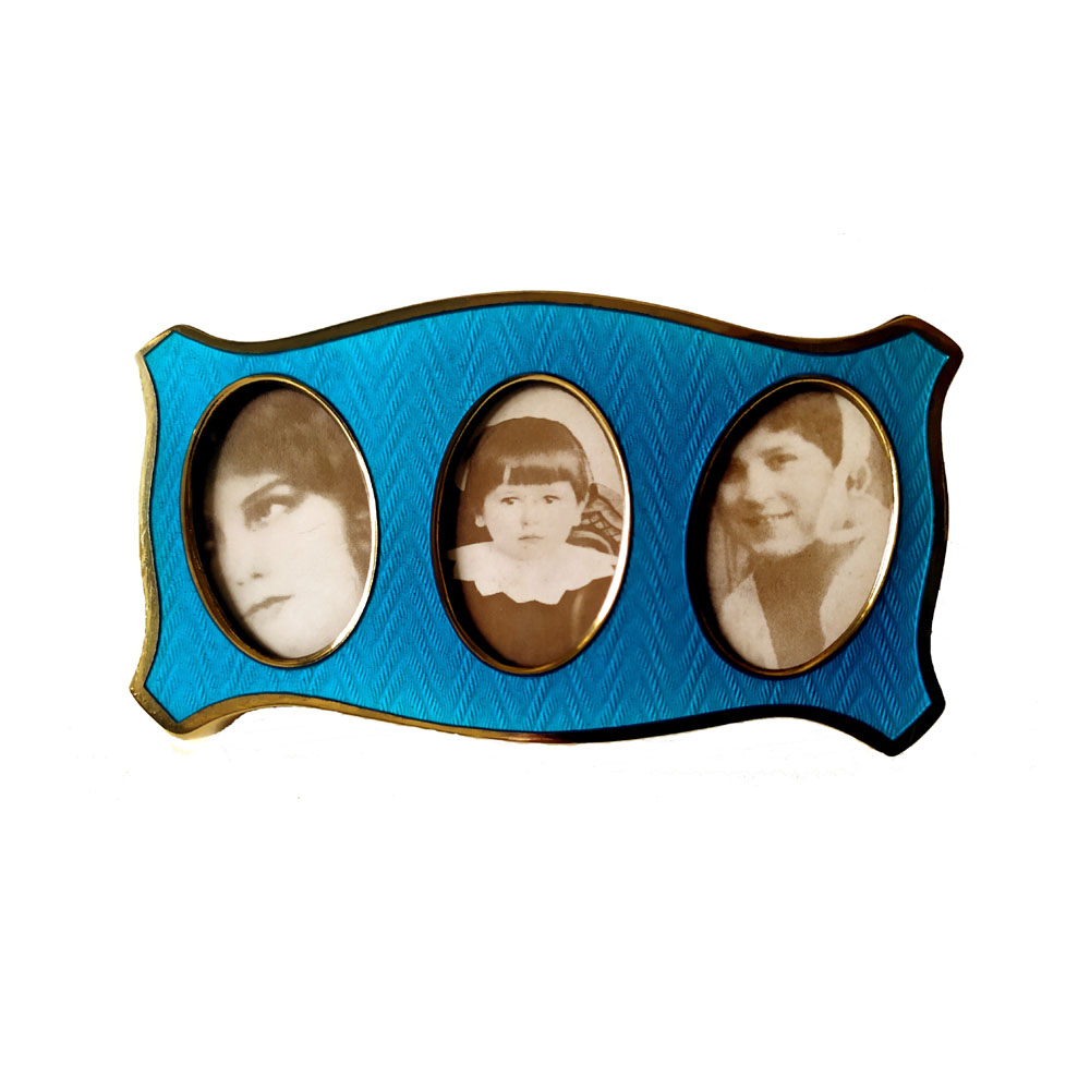 0229-1069- Shaped frame for 3 photographs in 925/1000 sterling silver gold plated with translucent fired enamels on guillochè. Modern Baroque style. Blue velvet panel. External measures cm. 5.5 x 10.2 with 3 oval interiors cm. 2.3 x 3.5. Weight gr. 52. Produced in Florence at the Salimbeni company headquarters in 1965 with manual workmanship by skilled artisan artists.