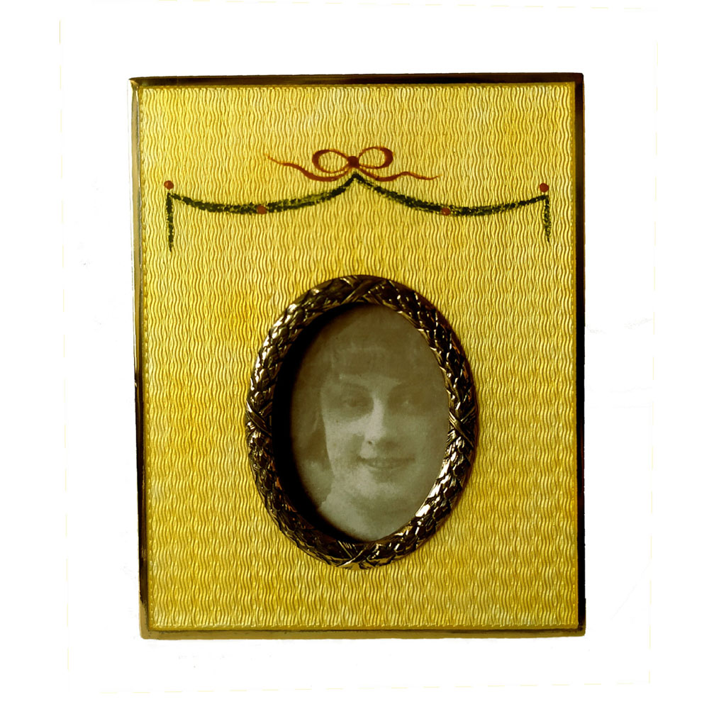 0760-4301 - Rectangular photo frame in 925/1000 sterling silver gold plated with translucent fired enamel on guillochè and hand-painted miniature of a garland of flowers with oval border internal size cm. 4 x 5.2 Russian Empire Faberge style. External cm. 10 x 13. Weight gr. 179. Designed by Franco Salimbeni in 1974 on inspiration from previous frames also manufactured in the Salimbeni company headquarters with manual processing by skilled artisan artists with a thick plate suitable for supporting numerous high-fire enamelled firings at around 800° C.