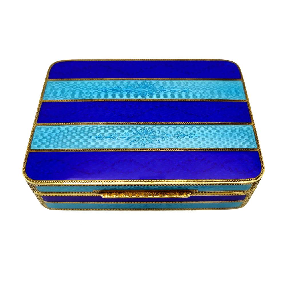 4446-5033 - Rectangular table box with rounded corners in 925/1000 sterling silver gold plated with two-tone translucent fired enamels with guillochè stripes and hand-engraved motifs. George V English Empire style. Dimensions cm. 8.3 x 11.3 x 3. Weight gr. 349. Designed by Giorgio Salimbeni in 1977 and reproduced in different specimens and different colors, in the Salimbeni company headquarters with manual workmanship by skilled artisan artists with thick slab and large reinforcements suitable for withstanding numerous high-fire enamelled firings at about 750 °