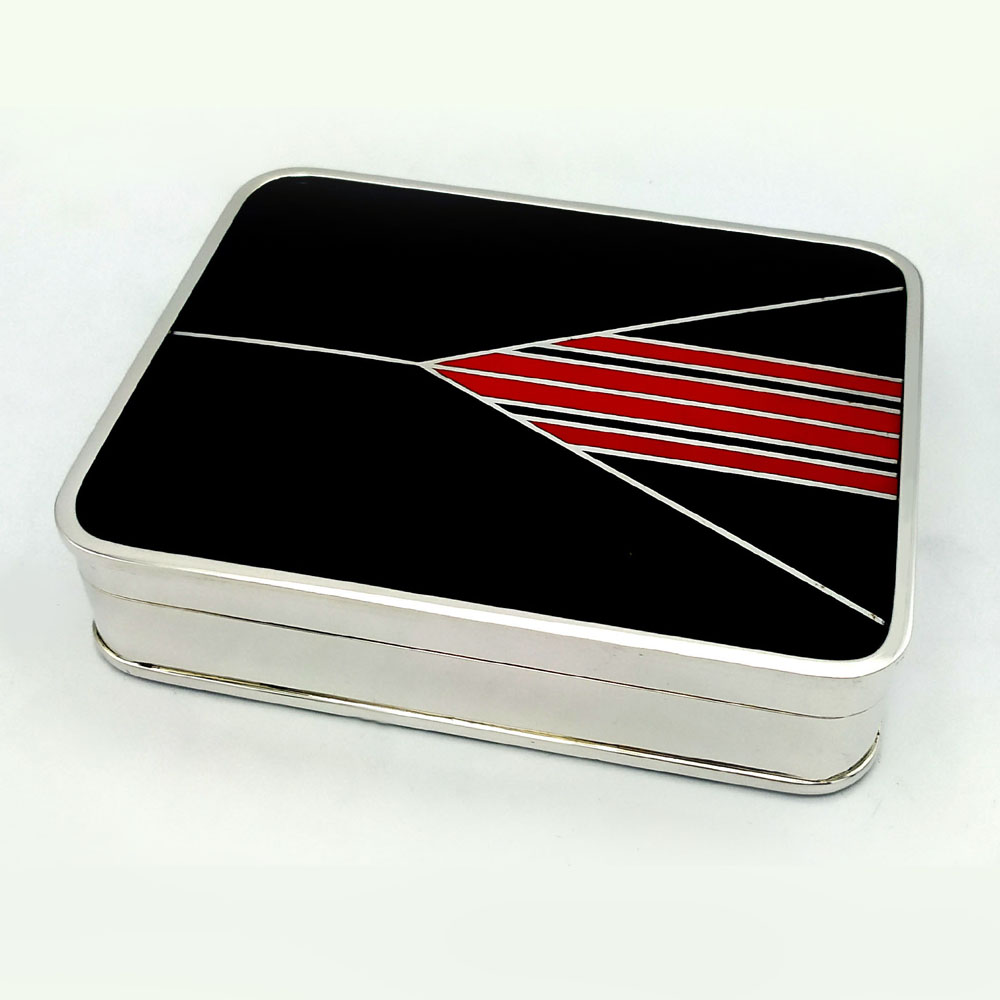 4671-5358 - Rectangular table box with rounded corners in 925/1000 sterling silver with fire-enamelled Art Deco design. Dimensions cm. 10.4 x 13.4 x 3.2. Weight gr. 530. Designed by Giorgio Salimbeni in 1976 inspired by objects designed by Louis Cartier around 1920 and manufactured in Florence in various specimens, also in parure with other objects and in different colors, in the Salimbeni company headquarters with completely manual execution by artisan artists with thick slab and large reinforcements suitable for supporting numerous high-fire enamelled firings at about 750°