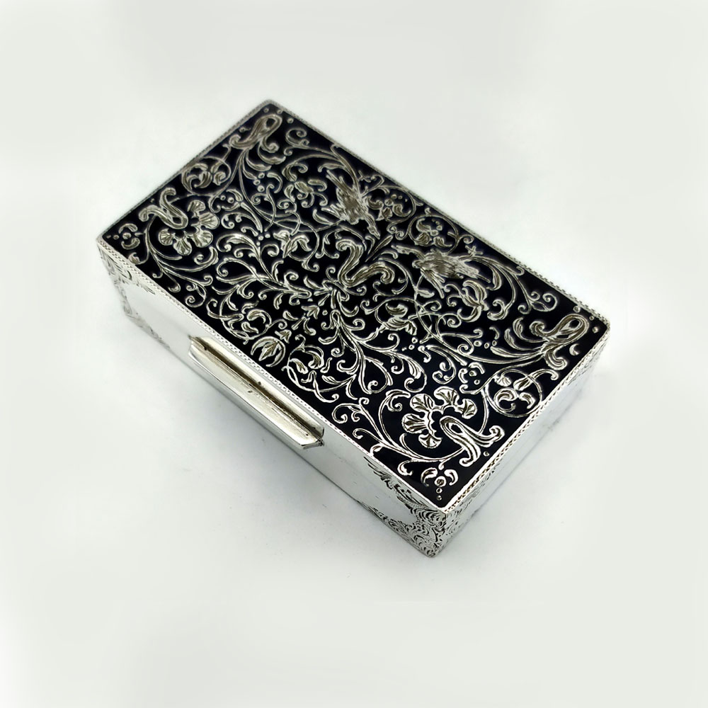 5326-6101 - Snuff Box rectangular in 925/1000 sterling silver with fine hand engraving, black fired enameled “niello” type, in early 19th century “Rococo” style. Snuff Box measurements cm. 4.5 x 7.7 x 2. Weight gr. 126. Designed by Franco Salimbeni in 1981 and produced in the Salimbeni company headquarters with manual workmanship by talented artisan artists with a very thick slab and large reinforcements suitable for supporting numerous high-fire enamelling firings at around 800° C.