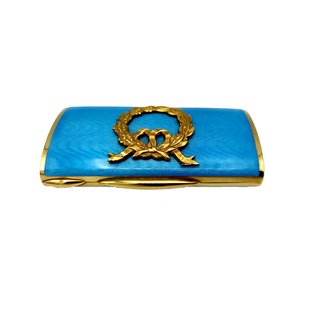 6202-7180 - Rectangular pocket snuff box with oval section in 925/1000 sterling silver gold plated with translucent fired enamel on guillochè, with laurel ornament in relief in Empire style. With lost hinge, i.e. semi-invisible. Dimensions cm. 4.3 x 8.2 x 1.7. Weight gr. 145. Designed by Franco Salimbeni in 1976 as a favor for a birth, with the initials of a child. Produced in Florence in the Salimbeni company headquarters, in numerous specimens for this occasion, and later for other needs with different ornaments and colors, always with manual workmanship by skilled artisan artists with thick slab and large reinforcements suitable for supporting numerous firings of high-fire enamelling at about 750°